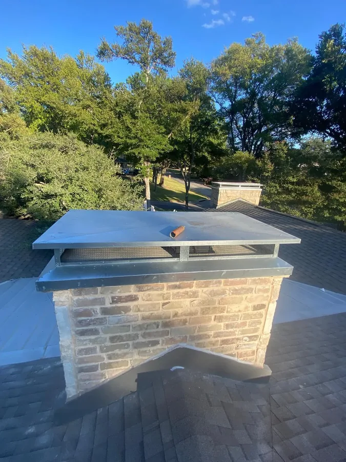Finished stainless mesh chimney cap installed on a brick chimney