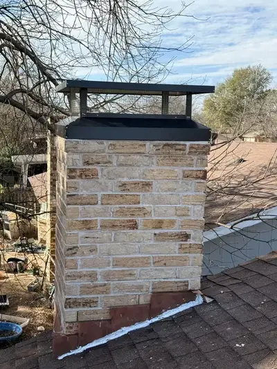 Rebuilt brick chimney with a new black chimney cap