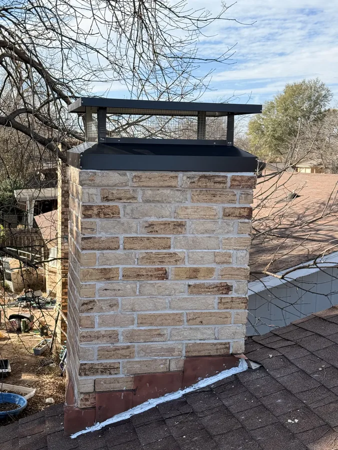Rebuilt brick chimney with a new black chimney cap